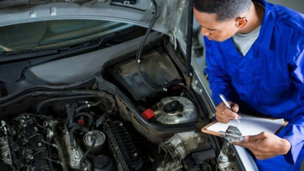personne qui inspecte la voiture et rédige un rapport