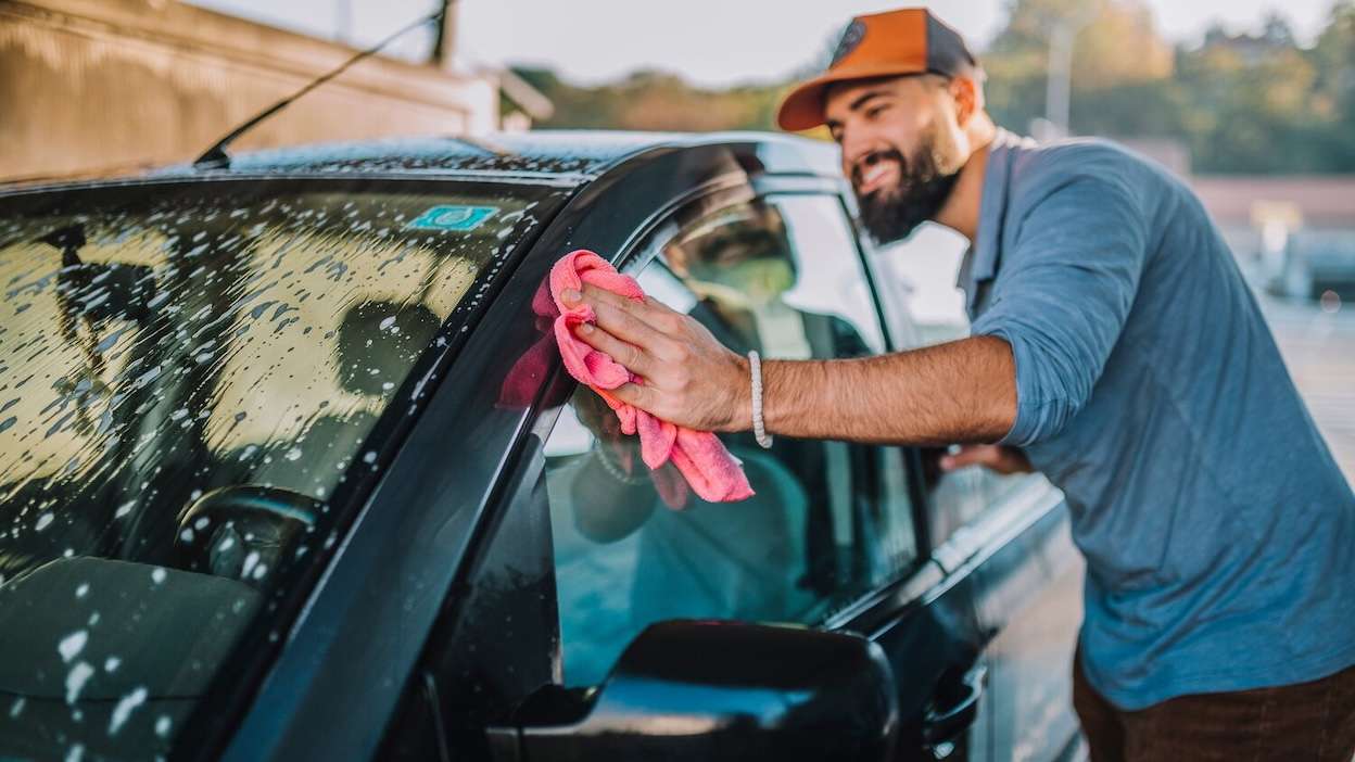 un homme qui nettoie une voiture
